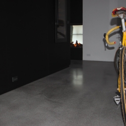 New yorker gulv installeret af PerBro Gulve i Kolding. Industrielt look med cykel og mørke vægge.