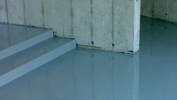 Blåt epoxy gulv i moderne betonbyggeri, leveret af PerBro Gulve i Kolding. Højglans overflade og minimalistisk design.