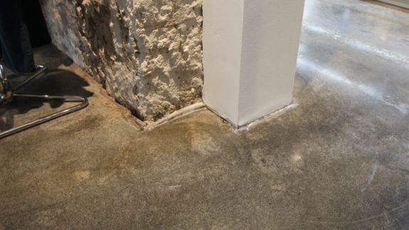 Detaljebillede af epoxy gulv i butik med rå vægge, leveret af PerBro Gulve i Kolding. Mat finish og slidstærk overflade.