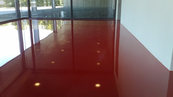 Rødt epoxy gulv i moderne kontorbyggeri fra PerBro Gulve i Kolding. Reflekterende overflade og glasfacade.